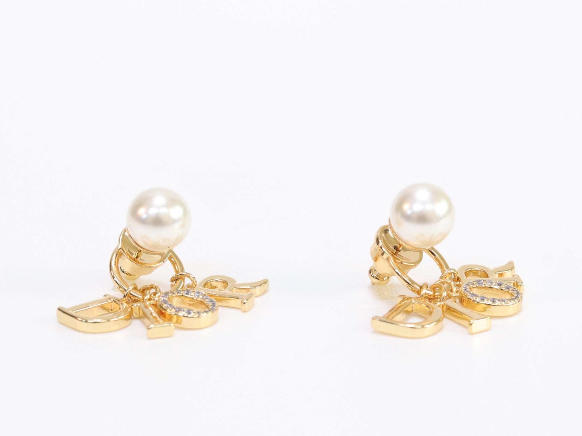 Alphabet CD dangling pearl studs in gold finish with CZ