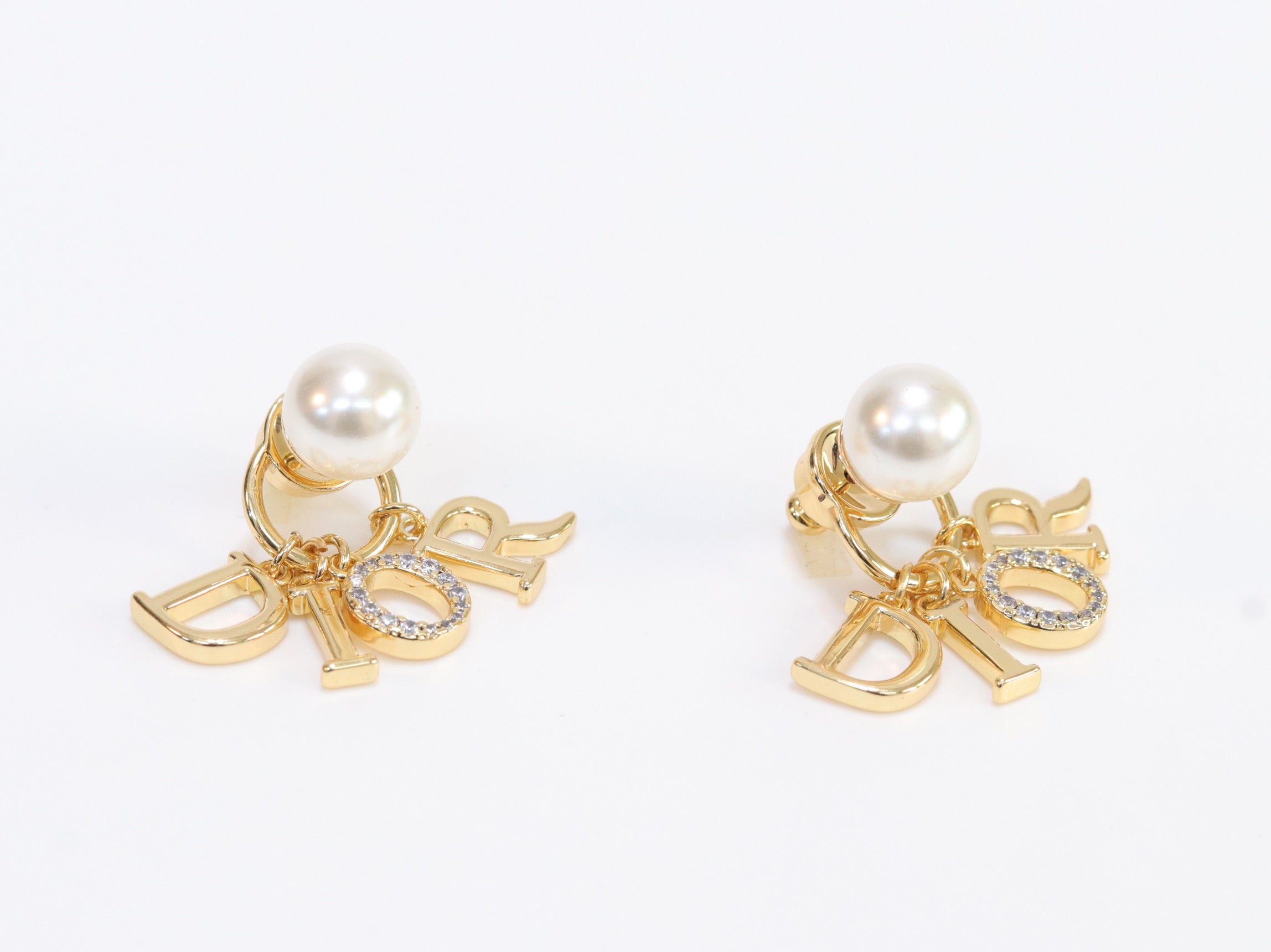 Alphabet CD dangling pearl studs in gold finish with CZ