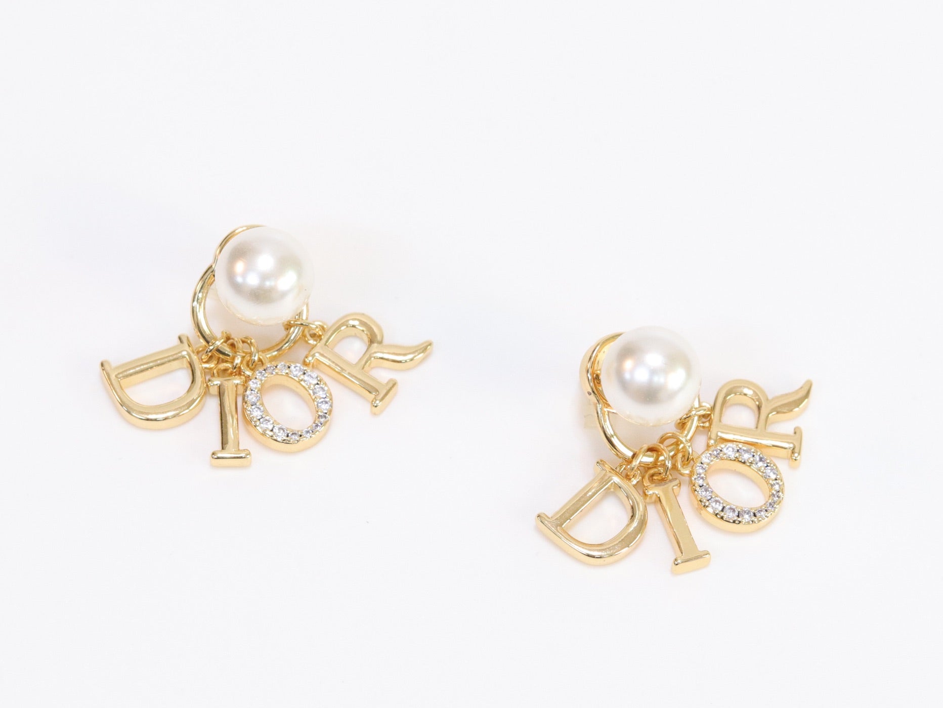 Alphabet CD dangling pearl studs in gold finish with CZ