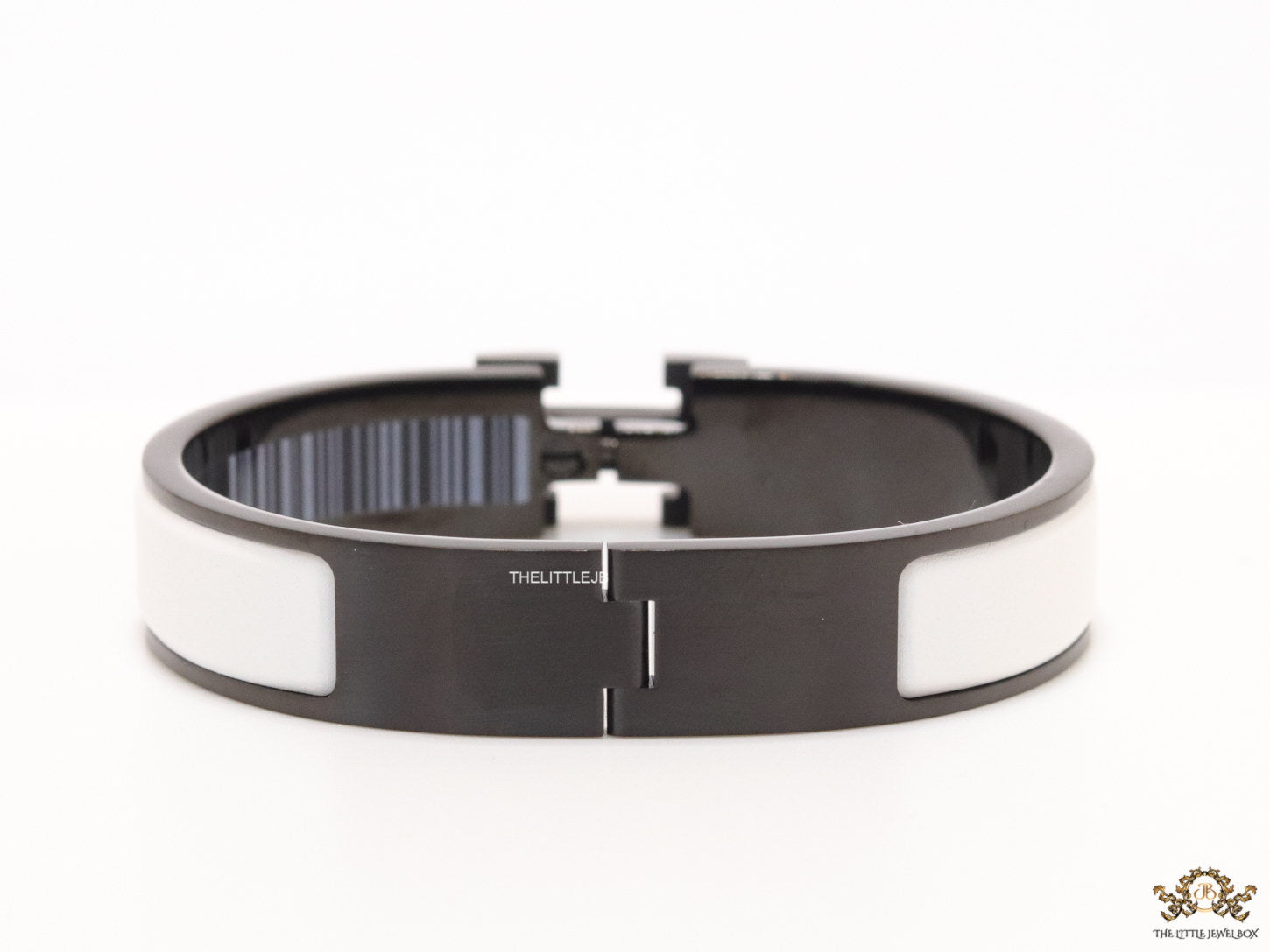 Premium collection band style bracelet in matt white with black metallic details and black T alphabet motif