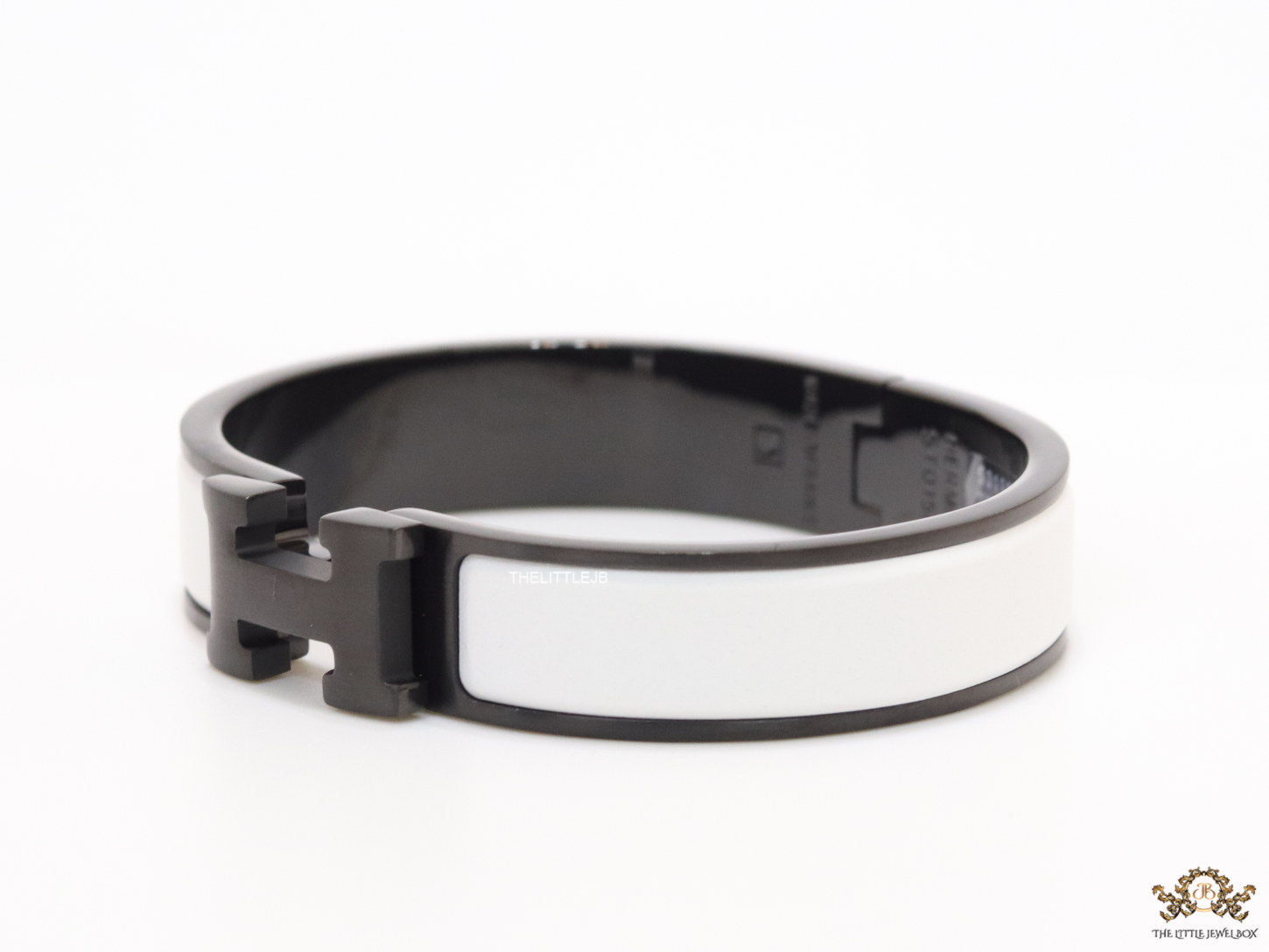 Premium collection band style bracelet in matt white with black metallic details and black T alphabet motif