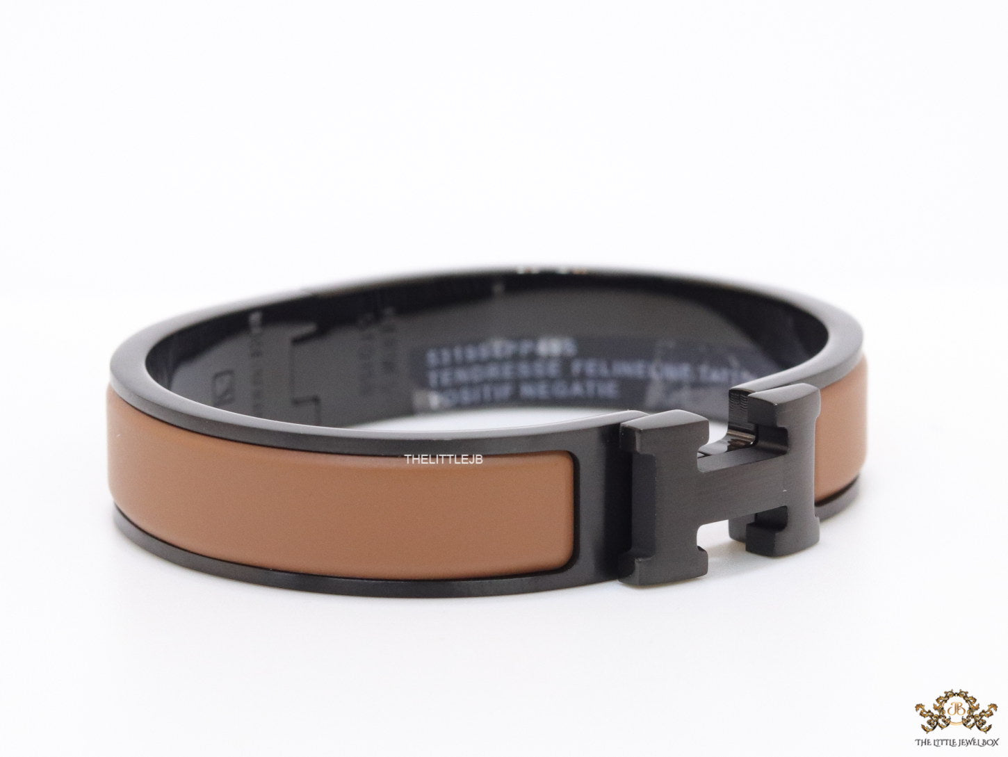 Premium collection band style bracelet in matt tan with black metallic details and black T alphabet motif