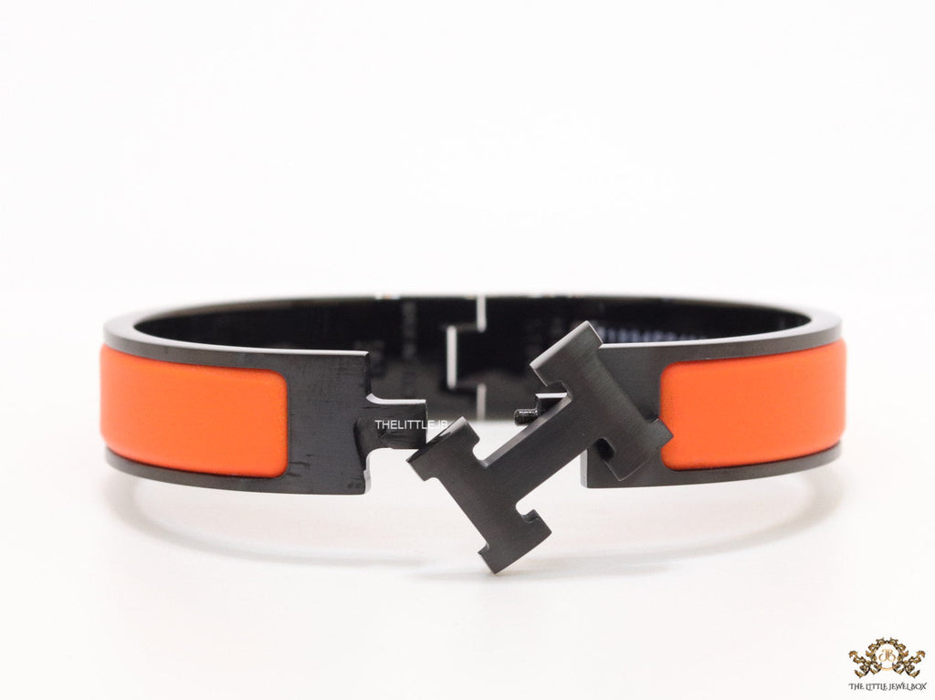 Premium collection band style bracelet in matt orange with black metallic details and black T alphabet motif