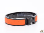 Premium collection band style bracelet in matt orange with black metallic details and black T alphabet motif