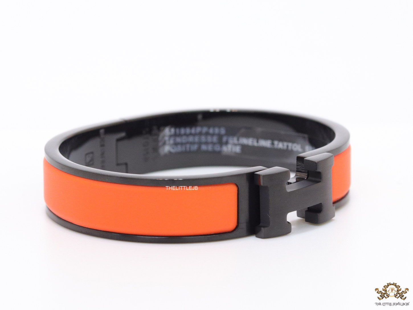 Premium collection band style bracelet in matt orange with black metallic details and black T alphabet motif