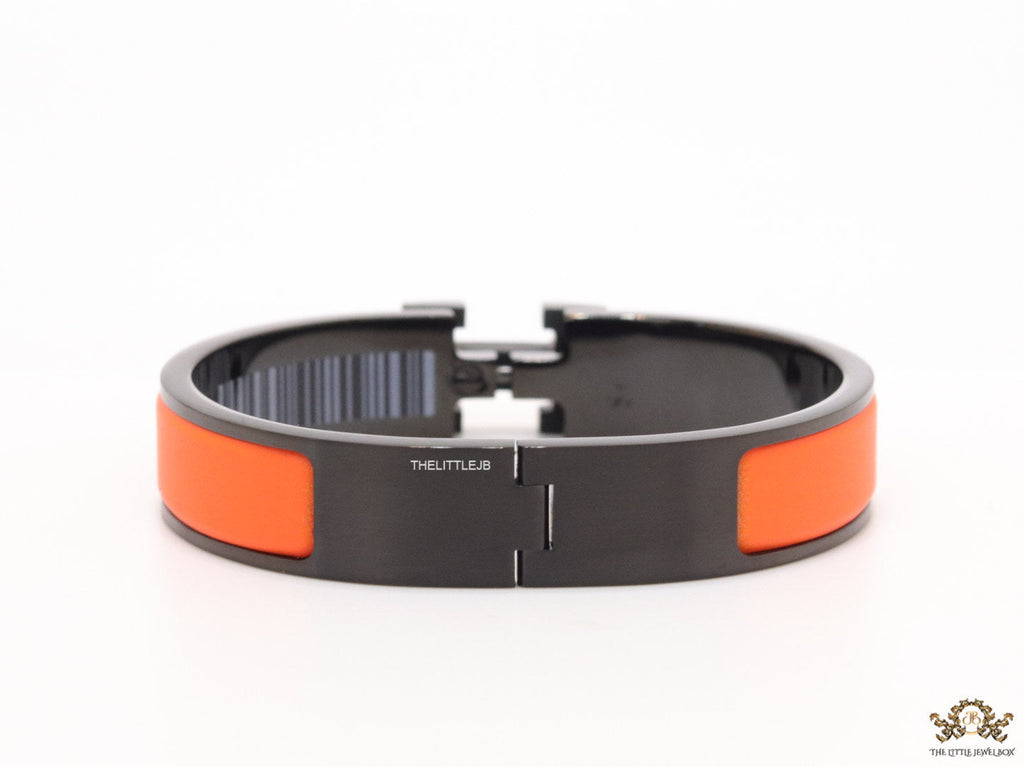 Premium collection band style bracelet in matt orange with black metallic details and black T alphabet motif