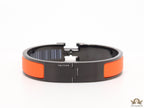 Premium collection band style bracelet in matt orange with black metallic details and black T alphabet motif
