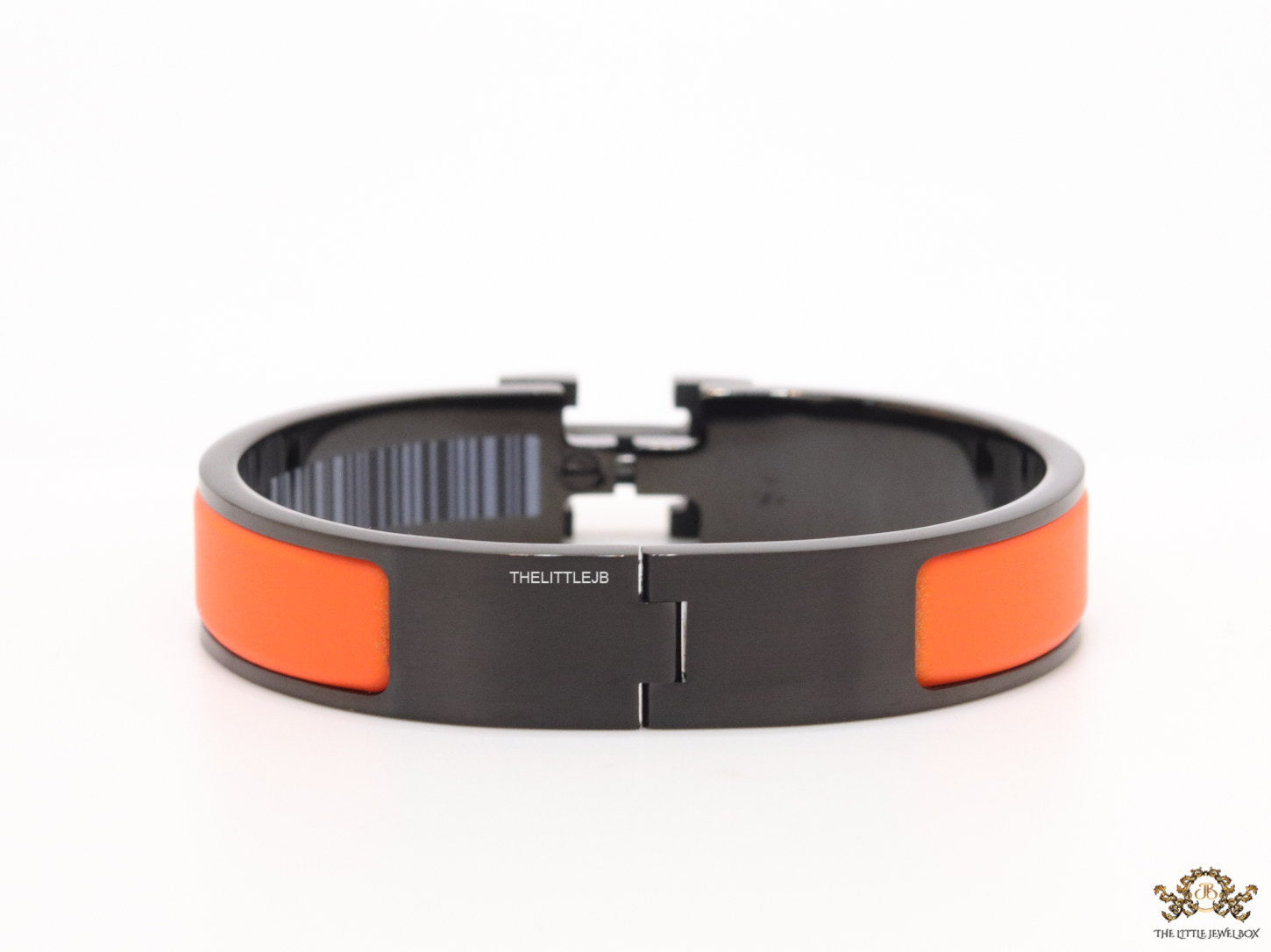 Premium collection band style bracelet in matt orange with black metallic details and black T alphabet motif
