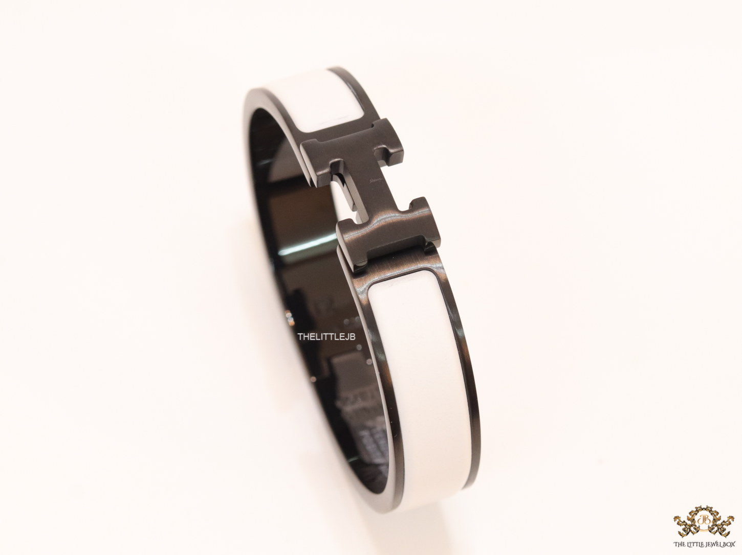 Premium collection band style bracelet in matt white with black metallic details and black T alphabet motif