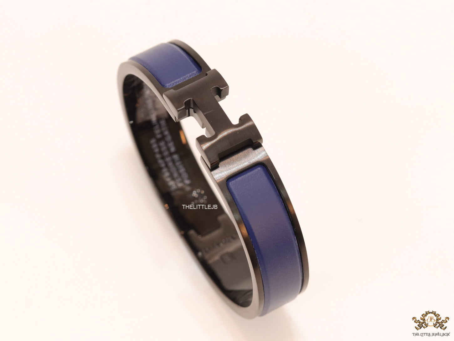 Premium collection band style bracelet in matt blue with black metallic details and black T alphabet motif