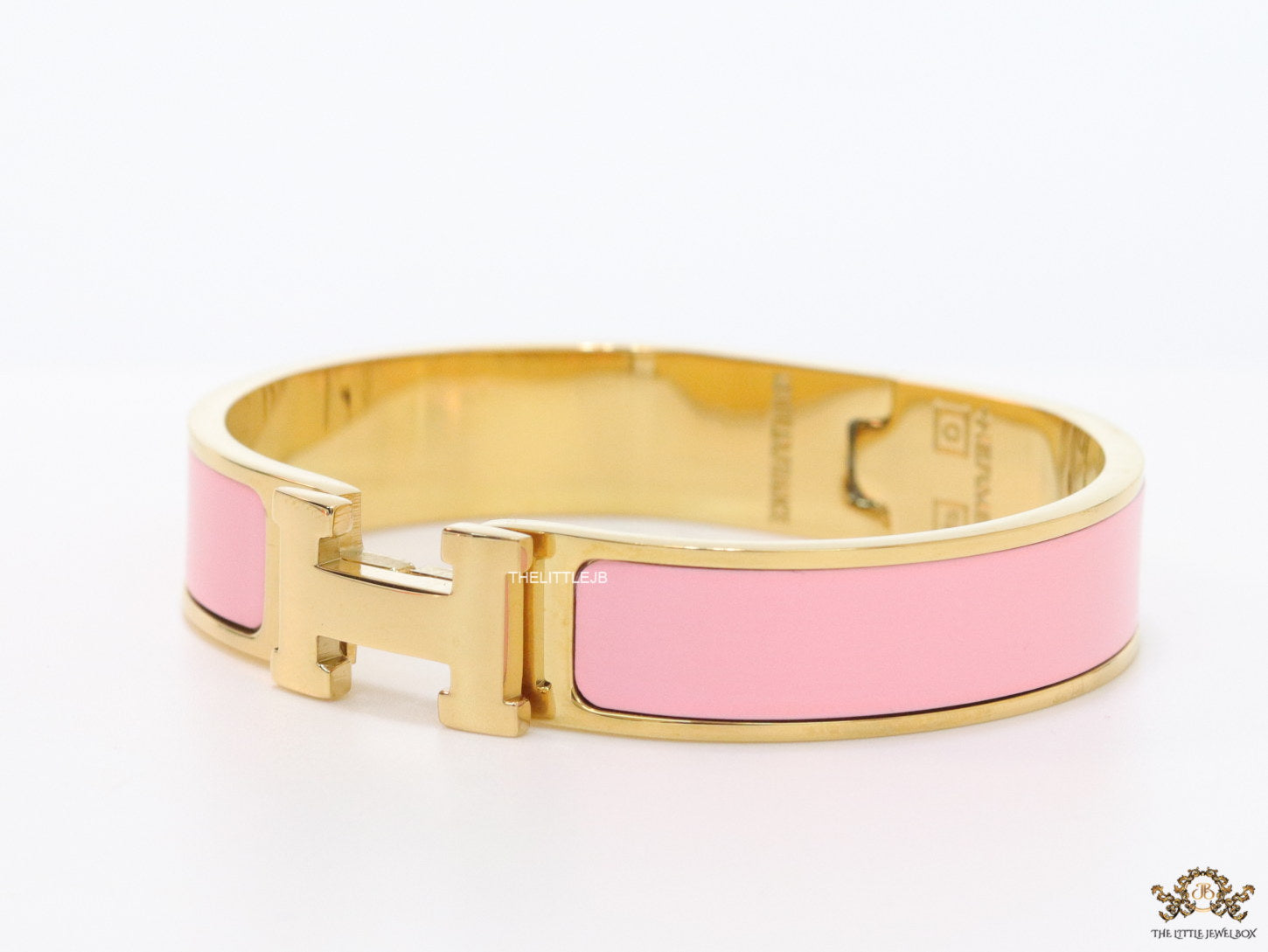 Premium range band style bracelet in pink colour with gold plated metallic details and gold plated T alphabet motif