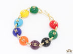 Gold plated link chain bracelet with multi coloured acrylic buttons with gold plated twin C alphabet