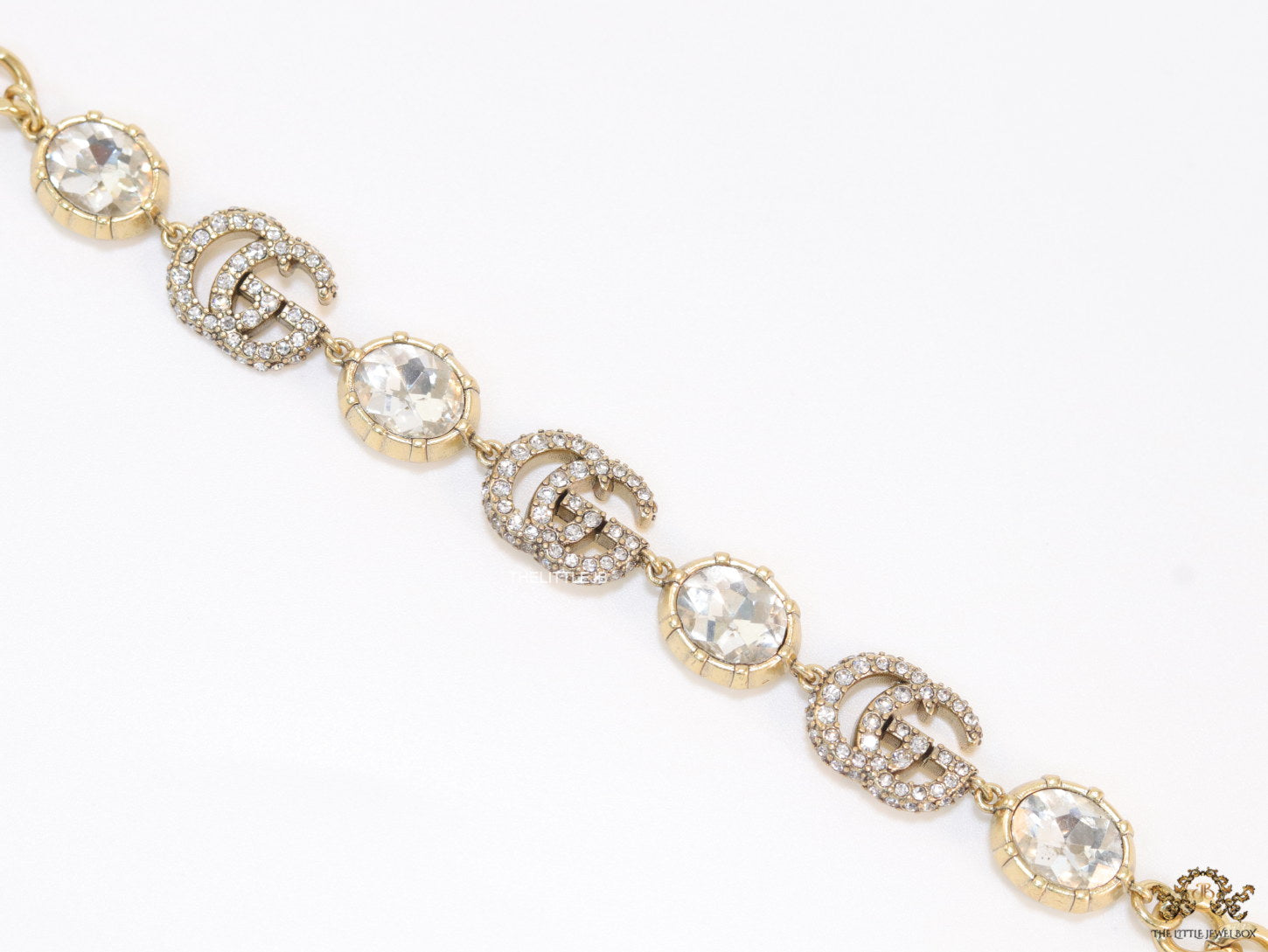 Gold plated linked chain bracelet with gold plated cubic zirconia stones twin G alphabet motifs and gold plated cubic zirconia stones