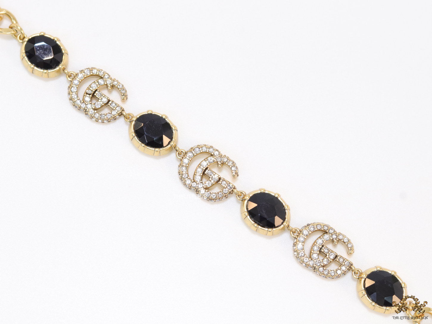 Gold plated linked chain bracelet with black stones and twin G alphabet motif