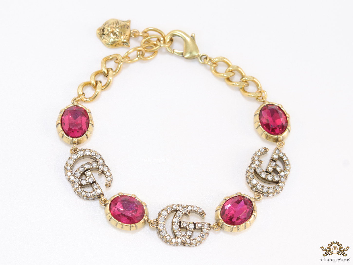 Gold plated linked chain bracelet with gold plated cubic zirconia stones twin G alphabet motifs and gold plated pink cubic zirconia stones