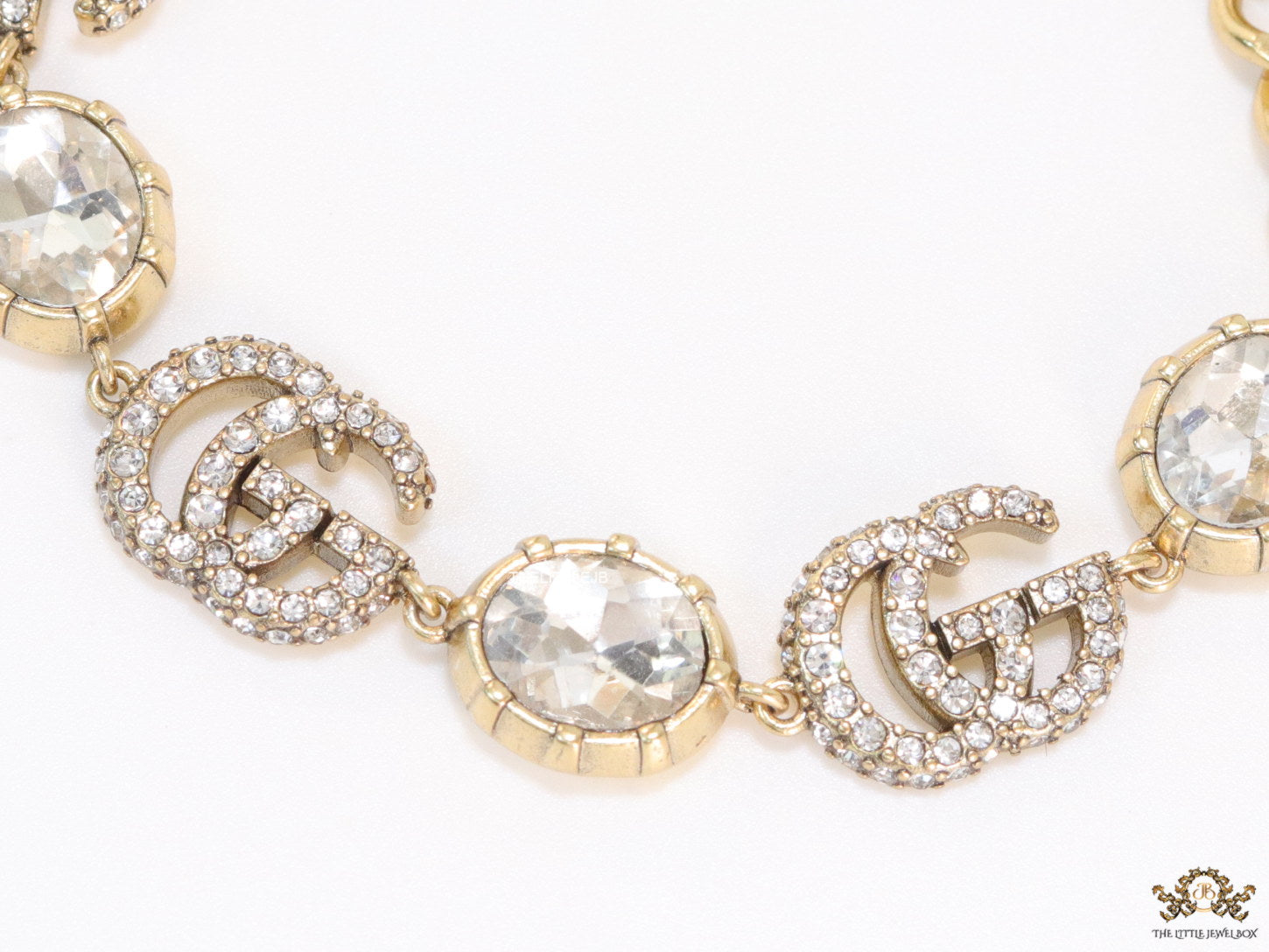 Gold plated linked chain bracelet with gold plated cubic zirconia stones twin G alphabet motifs and gold plated cubic zirconia stones