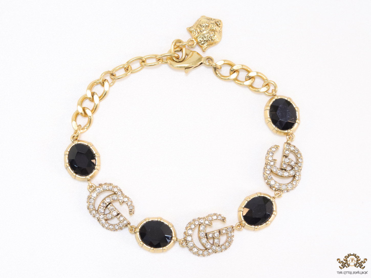 Gold plated linked chain bracelet with black stones and twin G alphabet motif