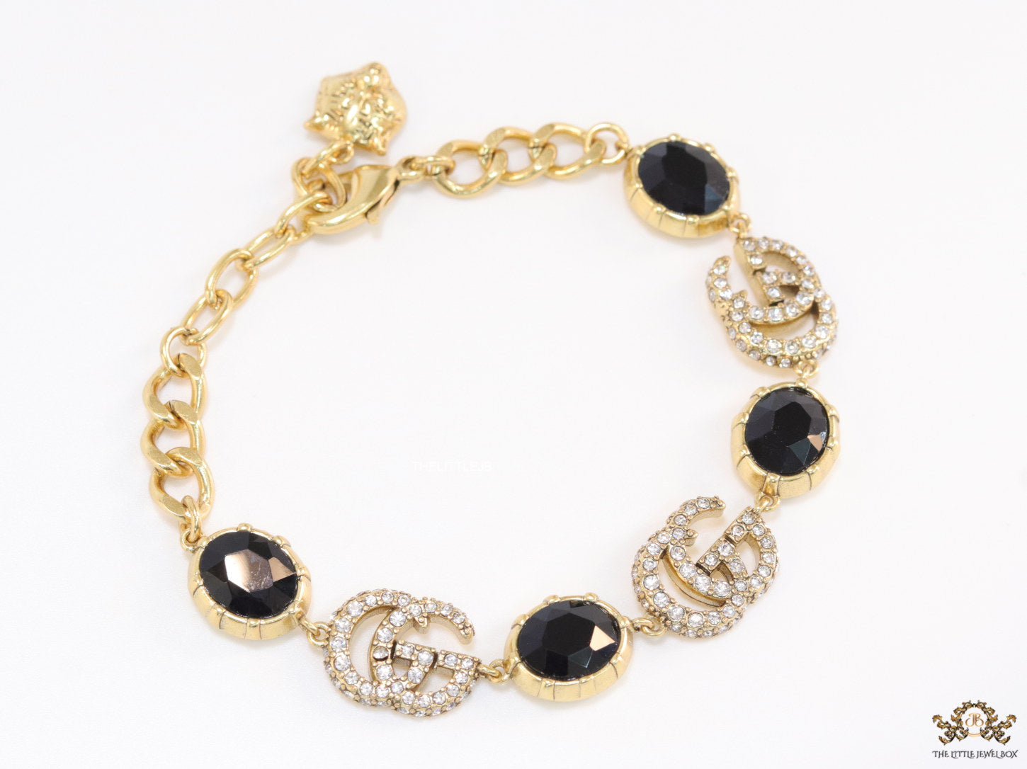 Gold plated linked chain bracelet with black stones and twin G alphabet motif