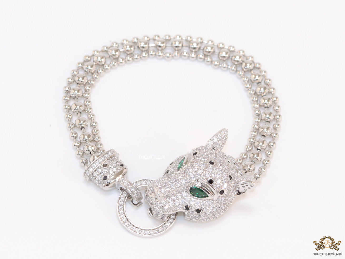 Platinum plated bracelet with cubic zirconia stones panther face motif with green cubic zirconia stone details and cubic zirconia stones disc