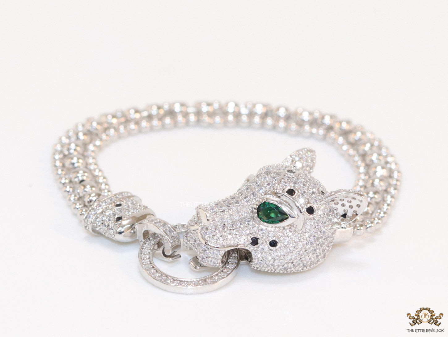 Platinum plated bracelet with cubic zirconia stones panther face motif with green cubic zirconia stone details and cubic zirconia stones disc