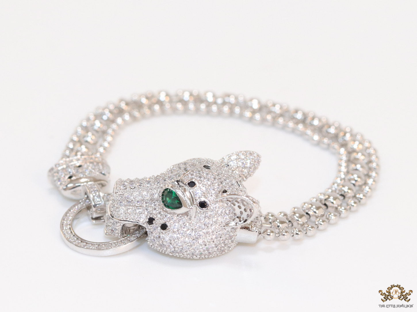 Platinum plated bracelet with cubic zirconia stones panther face motif with green cubic zirconia stone details and cubic zirconia stones disc
