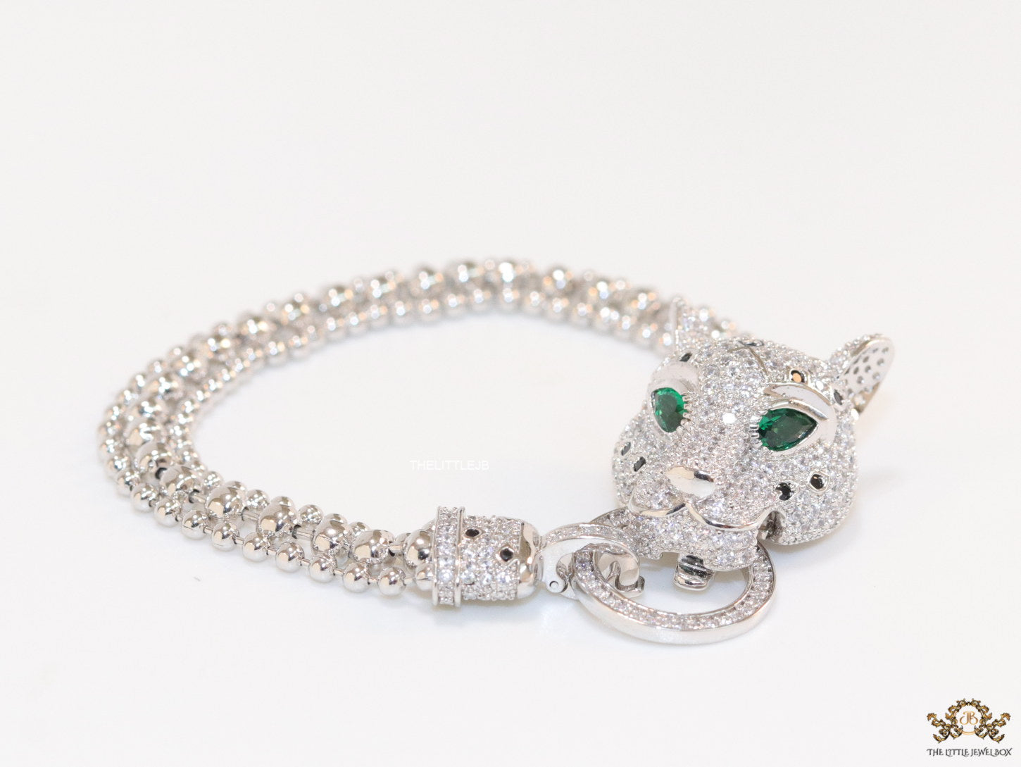 Platinum plated bracelet with cubic zirconia stones panther face motif with green cubic zirconia stone details and cubic zirconia stones disc