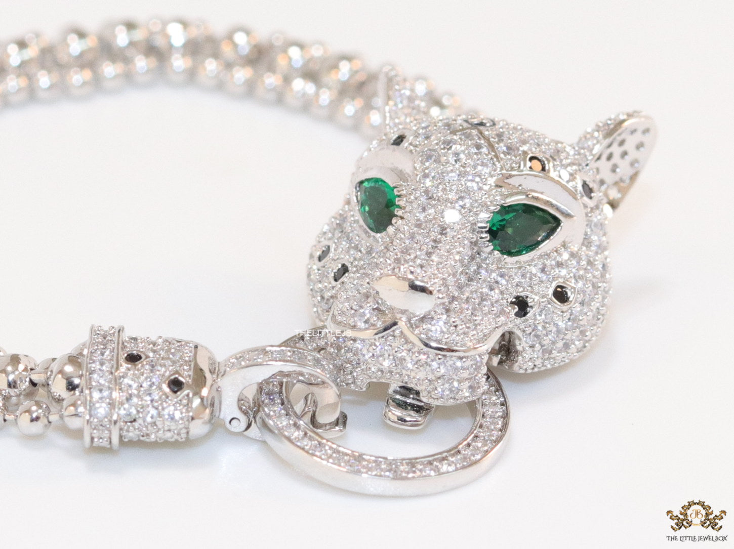 Platinum plated bracelet with cubic zirconia stones panther face motif with green cubic zirconia stone details and cubic zirconia stones disc