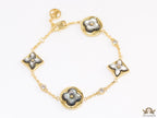 Sleek gold plated chain style bracelet with gold plated grey mother of pearl flower designs