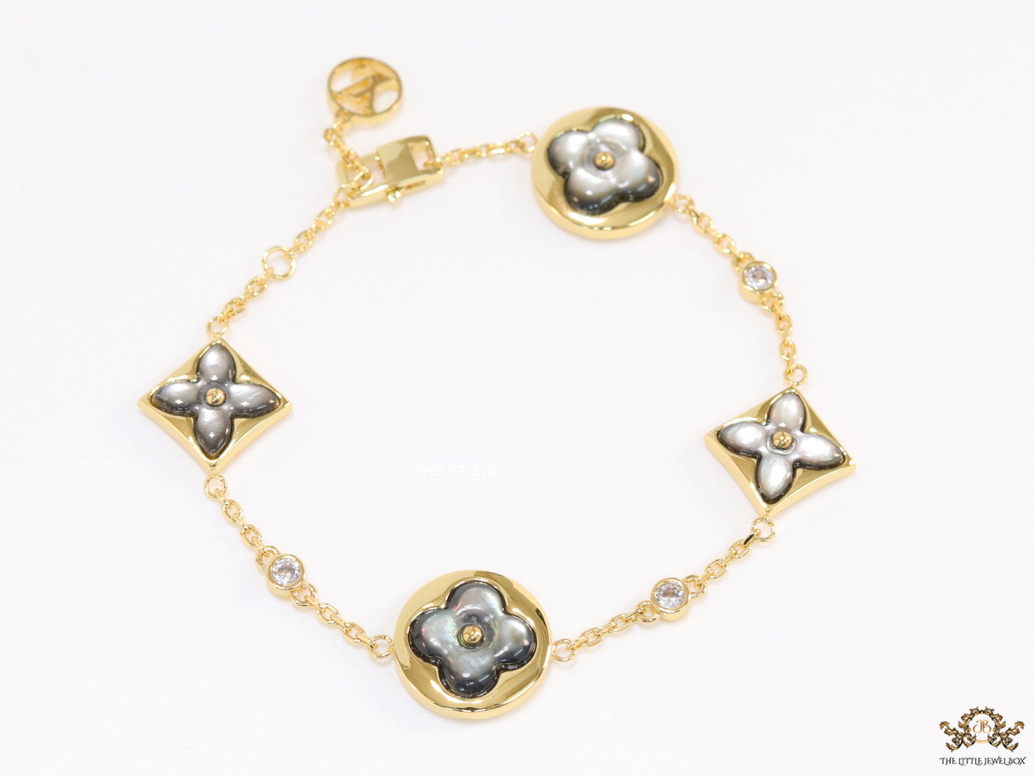 Sleek gold plated chain style bracelet with gold plated grey mother of pearl flower designs