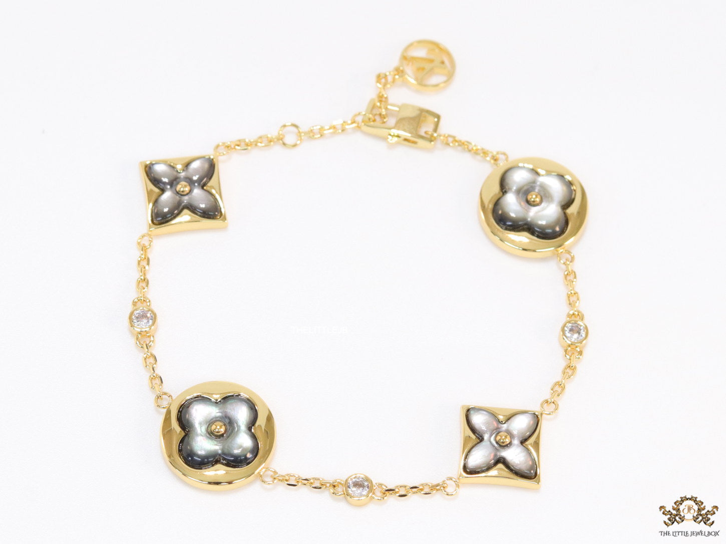 Sleek gold plated chain style bracelet with gold plated grey mother of pearl flower designs