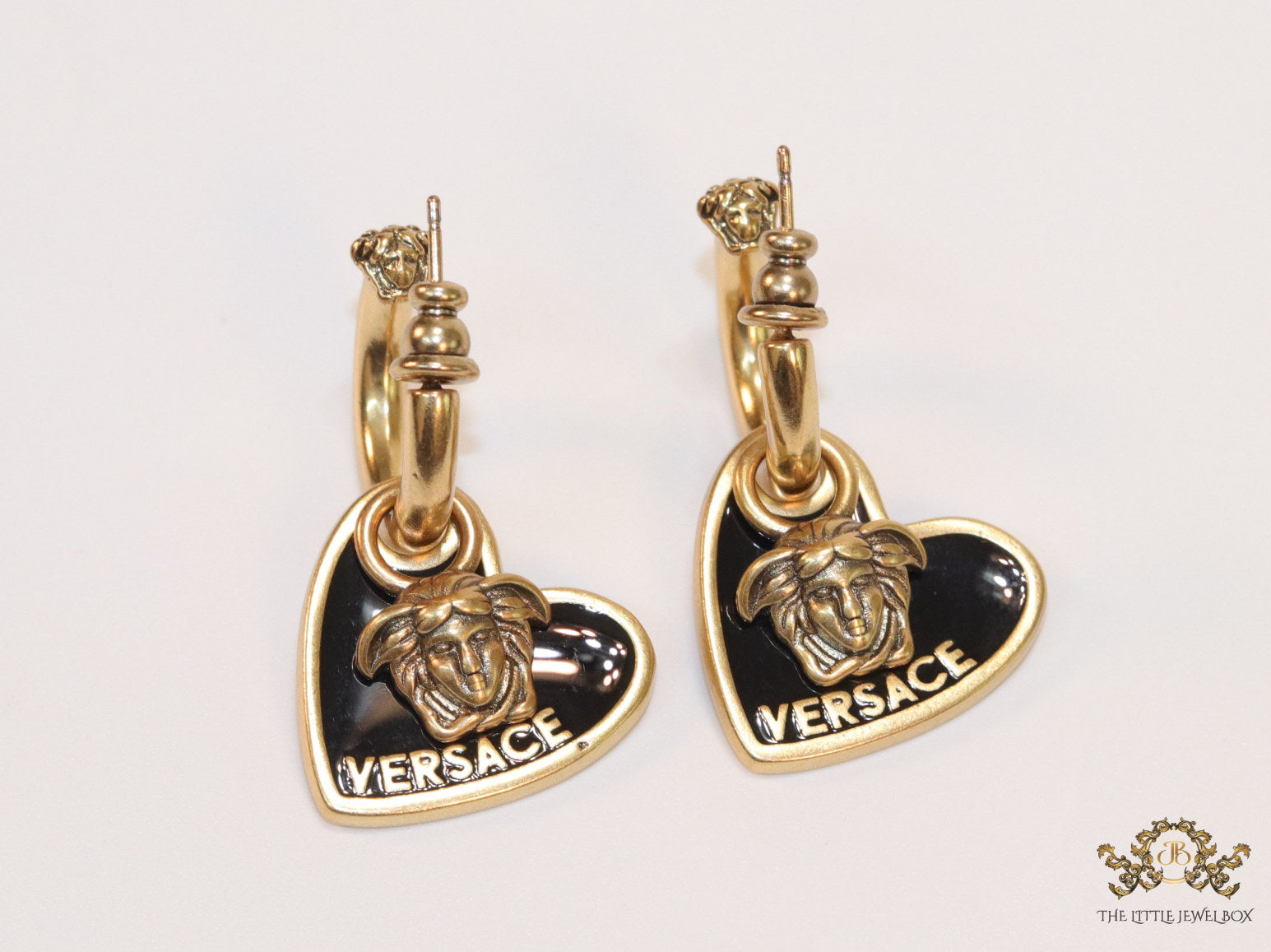 Golden and black enamel heart shape medusa earrings