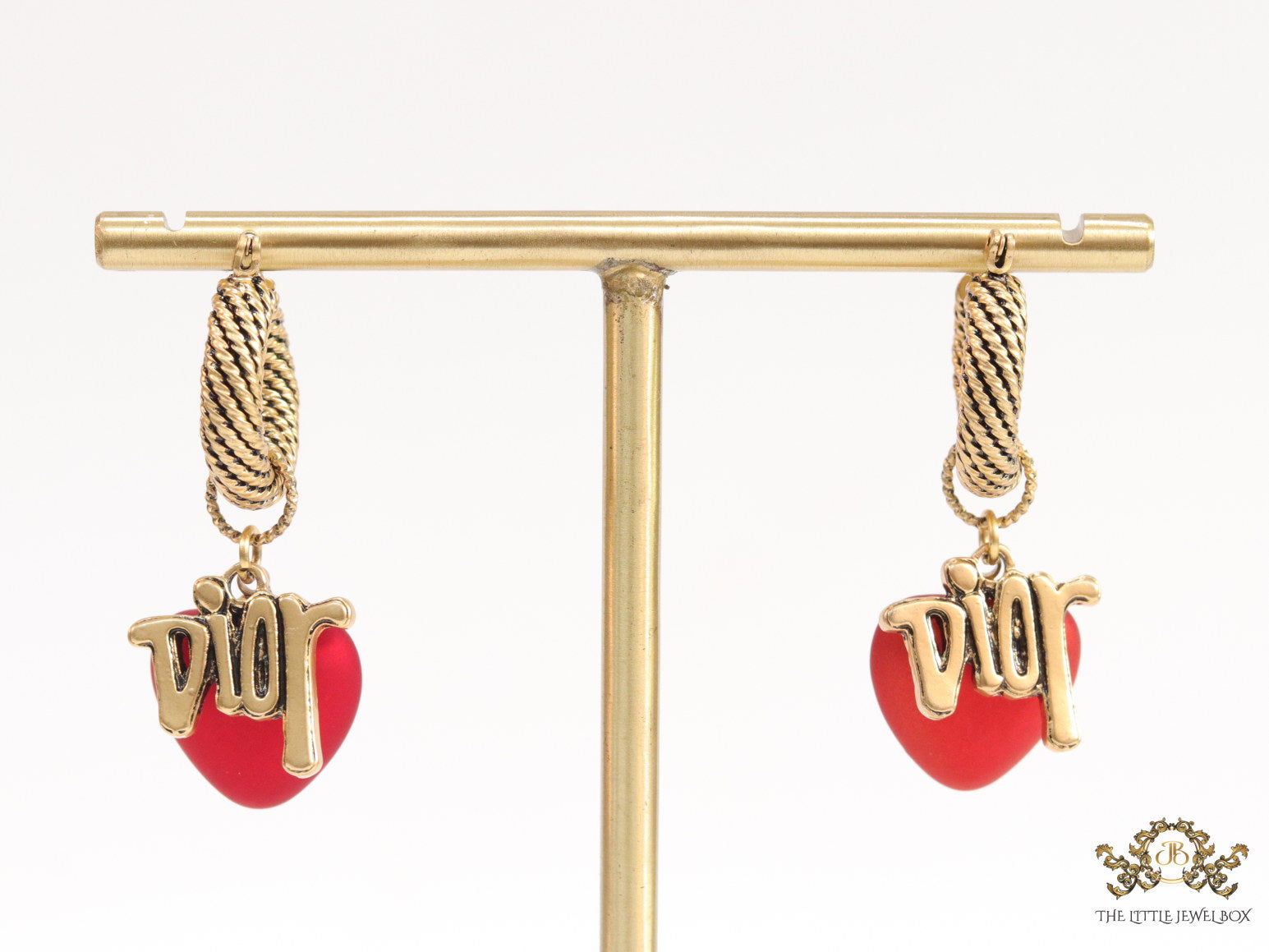 Golden hoops with alphabets and red pearl drop