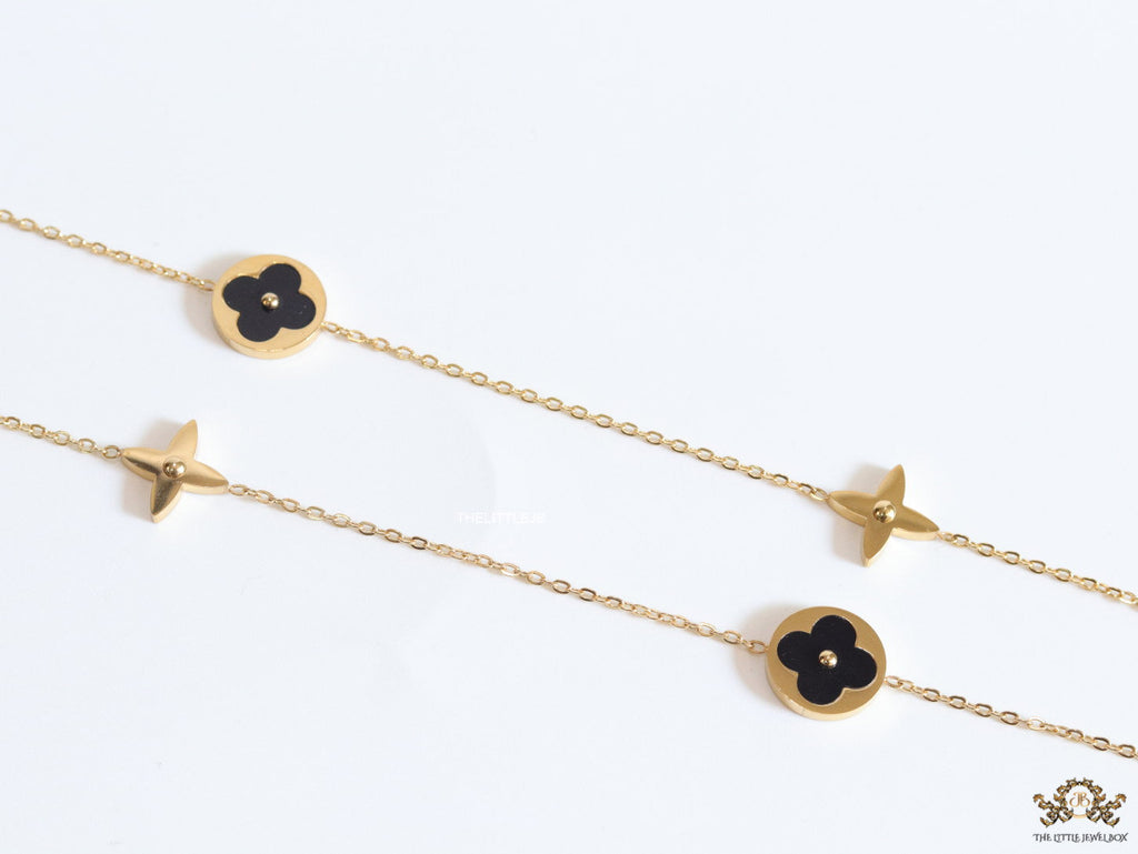 Golden chain necklace with black enamel clovers