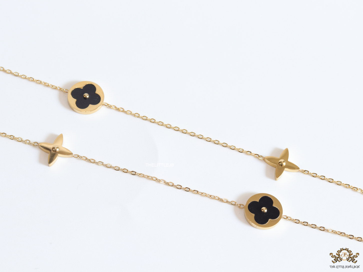 Golden chain necklace with black enamel clovers