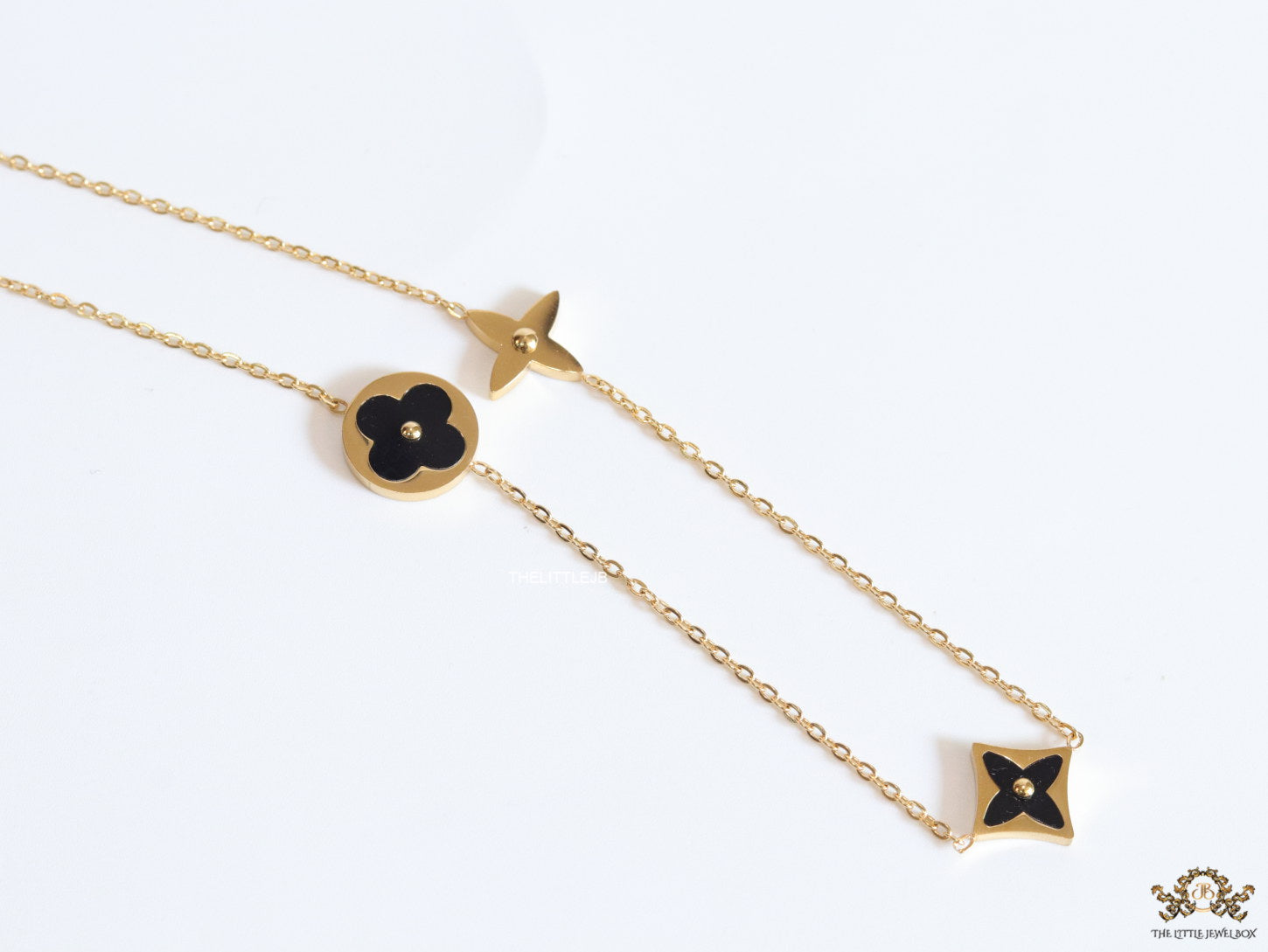 Golden chain necklace with black enamel clovers