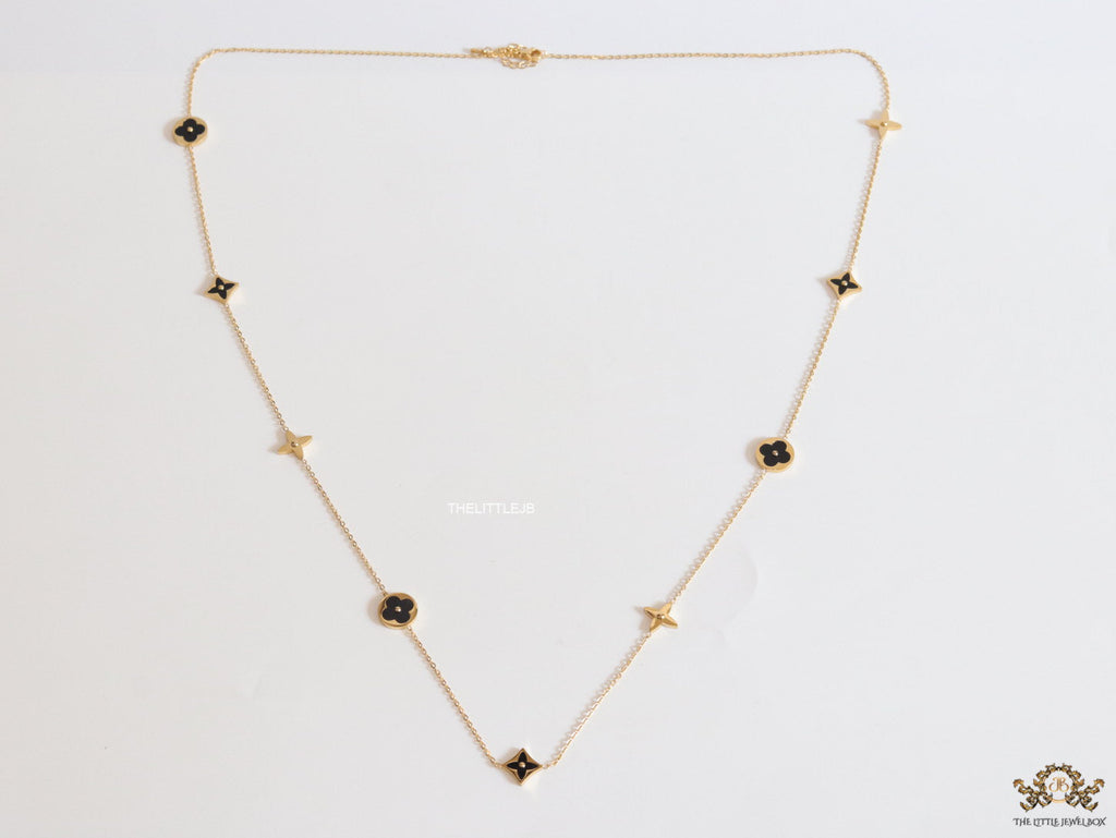 Golden chain necklace with black enamel clovers