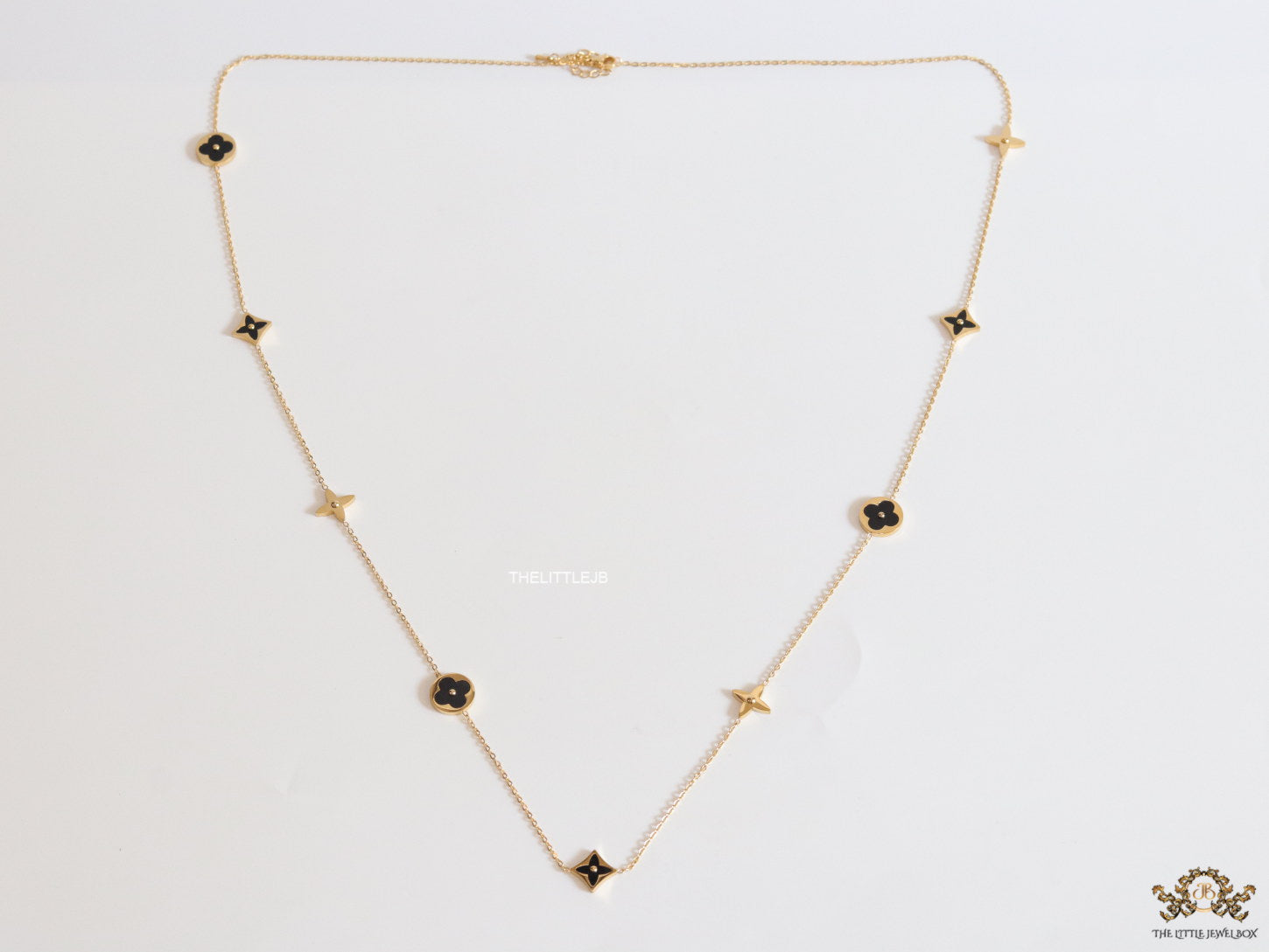 Golden chain necklace with black enamel clovers