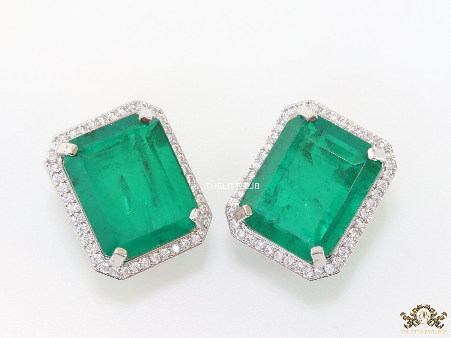 Platinum plated studs with emerald green doublet stone and white cubic zirconia stones lining