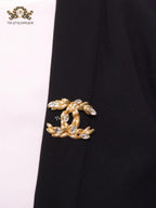 Twin C brooch in matte gold and fancy cz