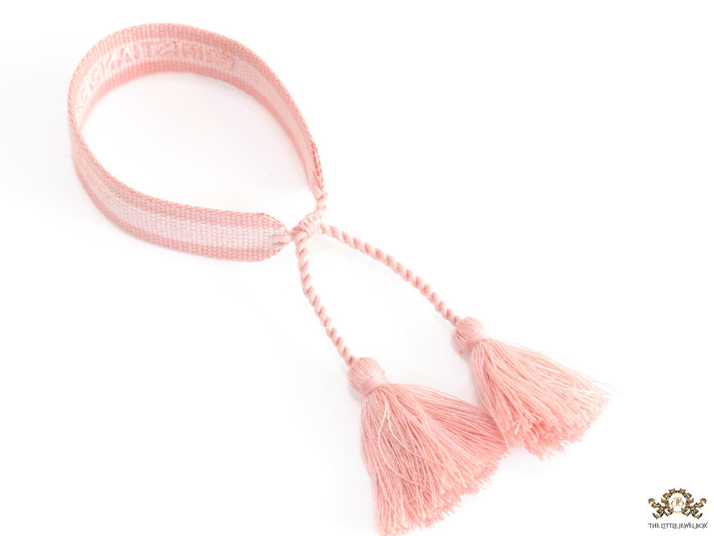 Adjustable pastel pink woven bracelet with knitted alphabets and tassels