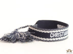 Adjustable dark grey woven bracelet with knitted alphabets and tassels