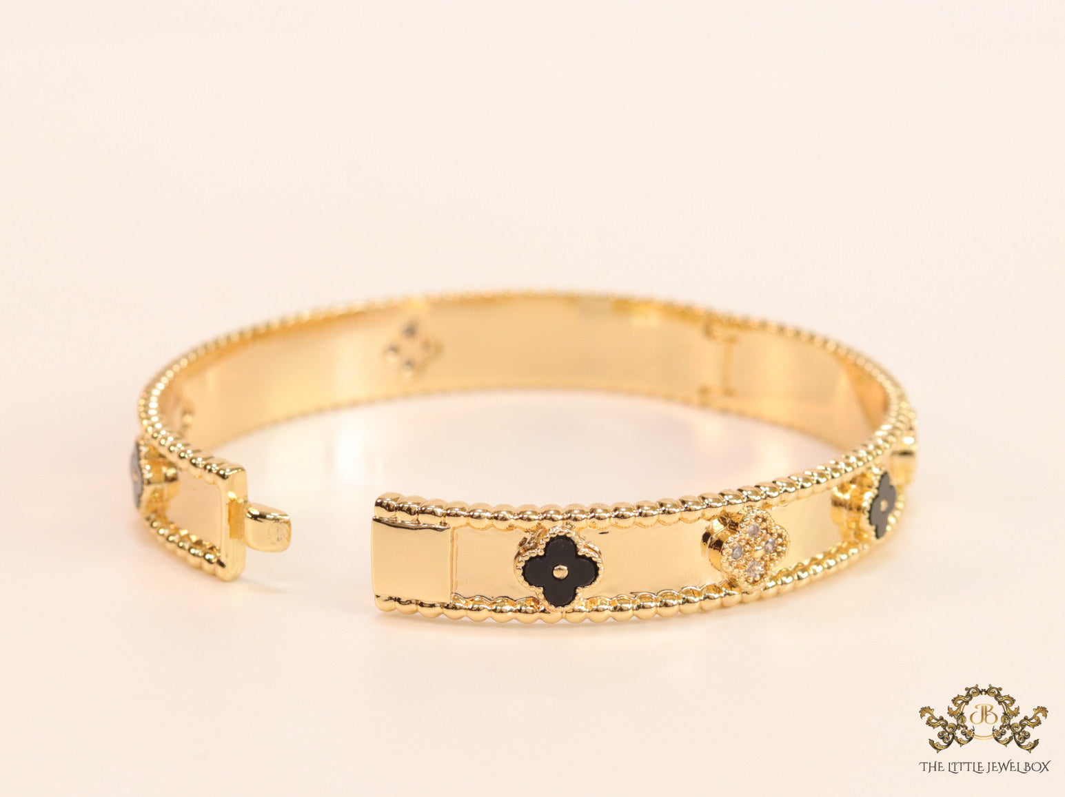 Gold plated bracelet with clover motifs in cz and black enamel