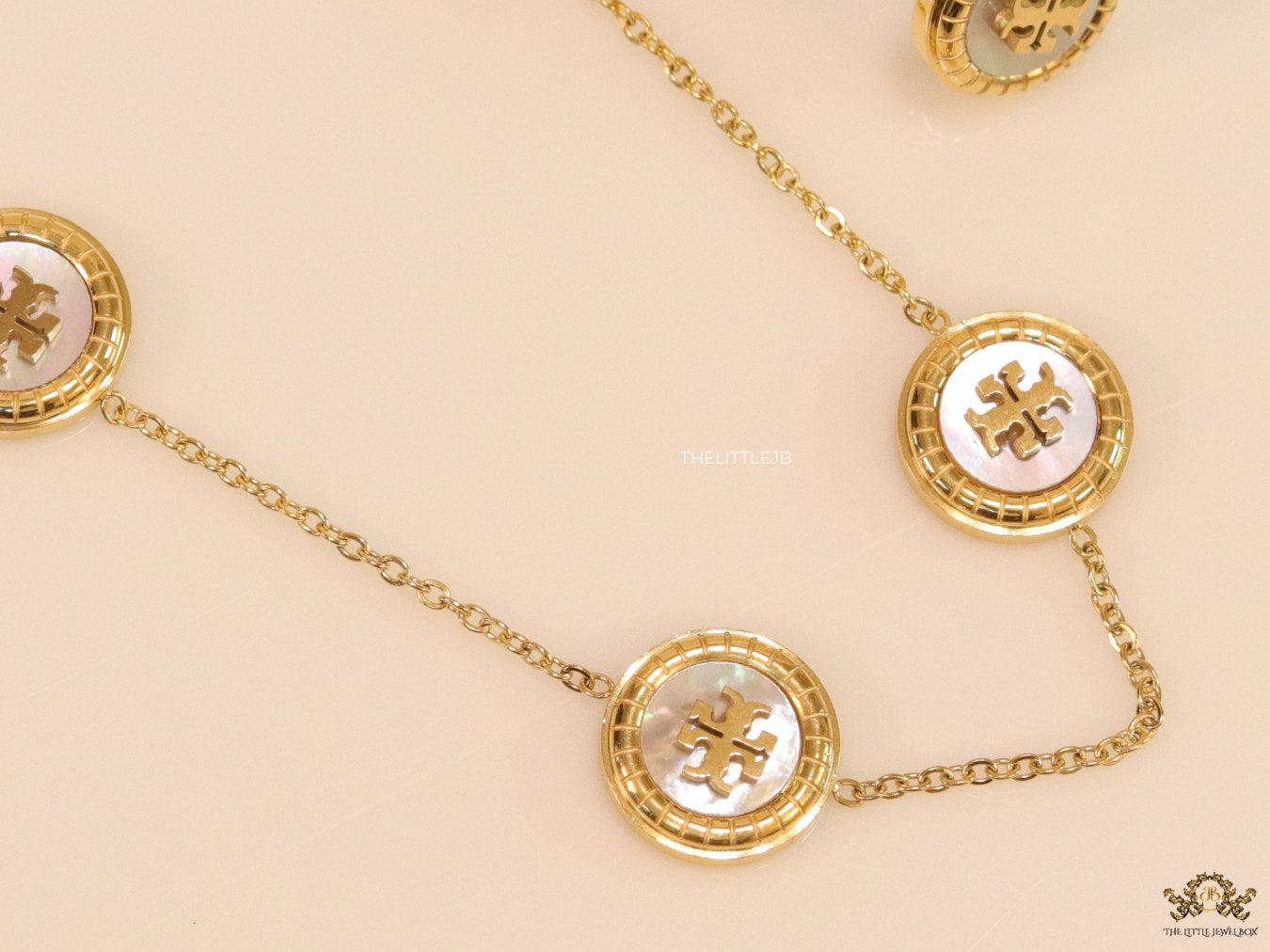 Gold plated necklace set with T motif mother of pearl discs