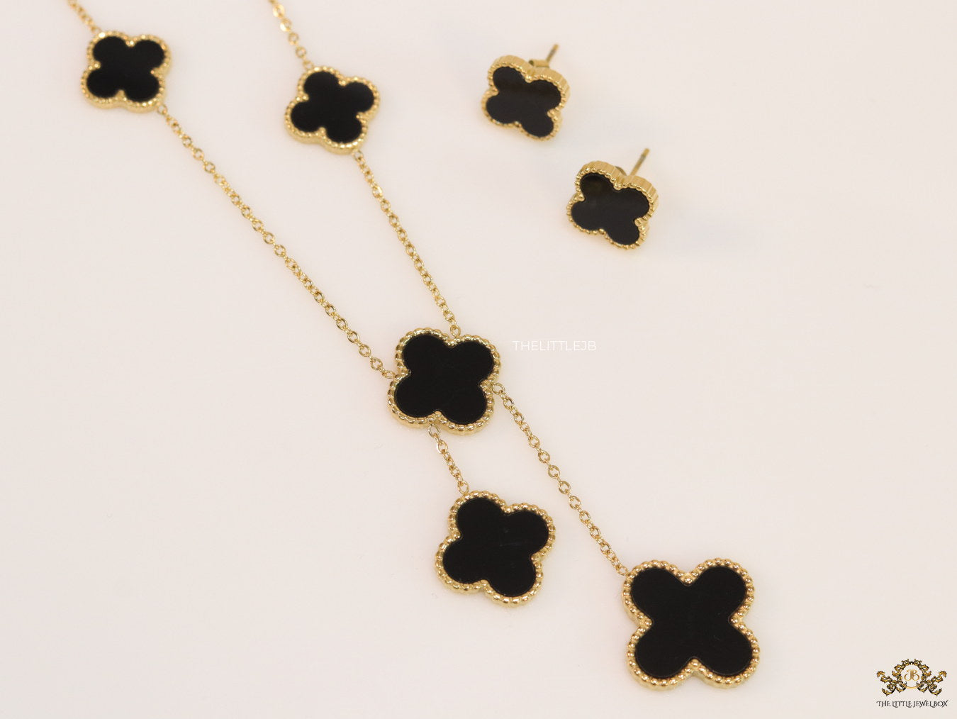 Gold plated necklace set with black enamel coated clovers