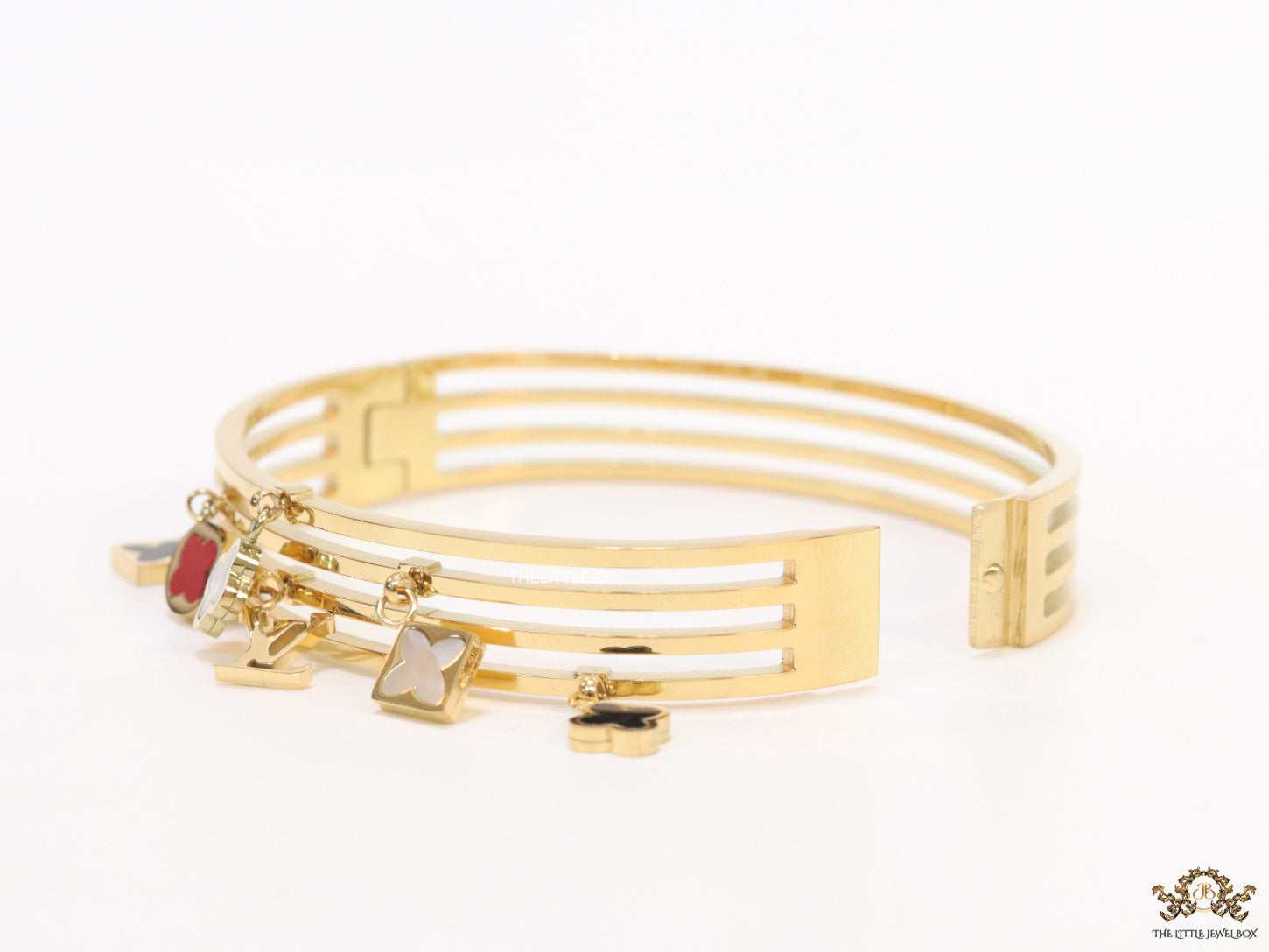 Multilayered golden bracelet with alphabets and coloured clover charms