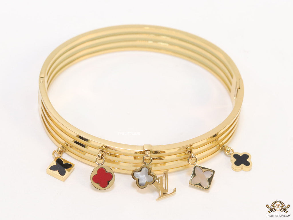 Multilayered golden bracelet with alphabets and coloured clover charms