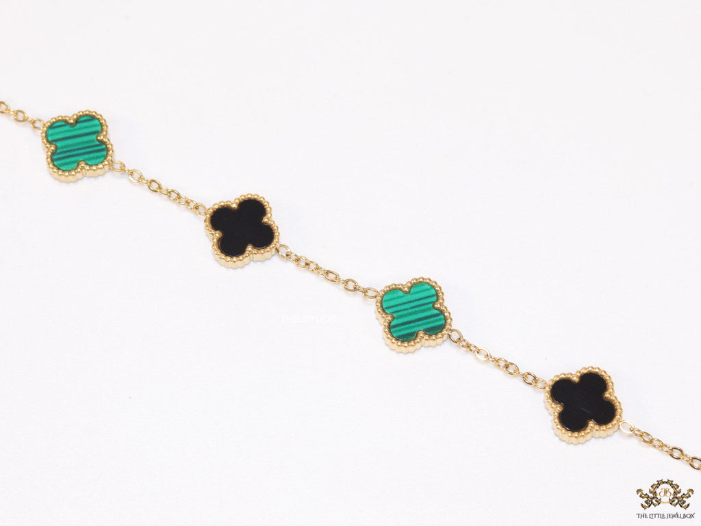 Golden chain bracelet with black and green clovers