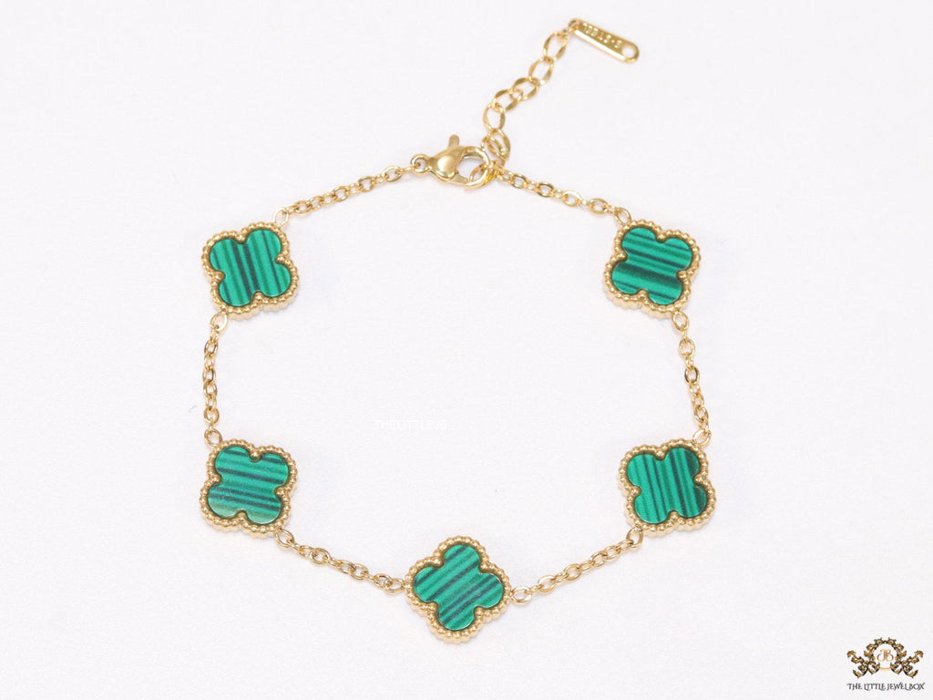 Golden chain bracelet with black and green clovers