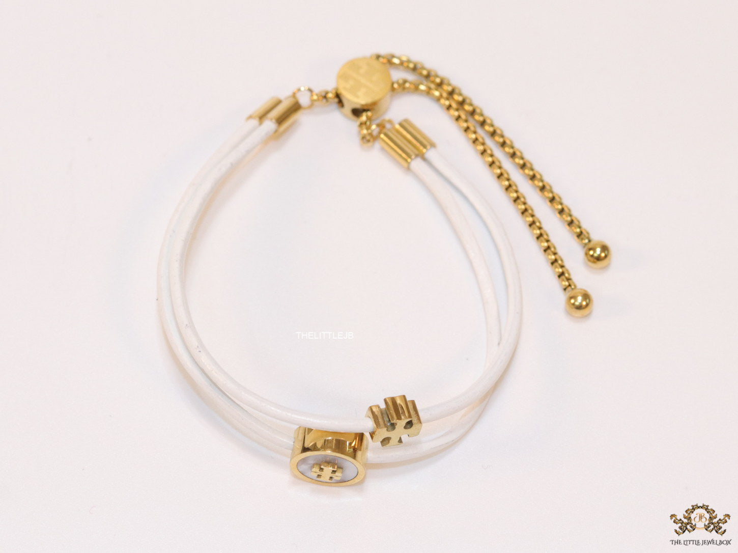 Adjustable double string white bracelet with twin T motifs