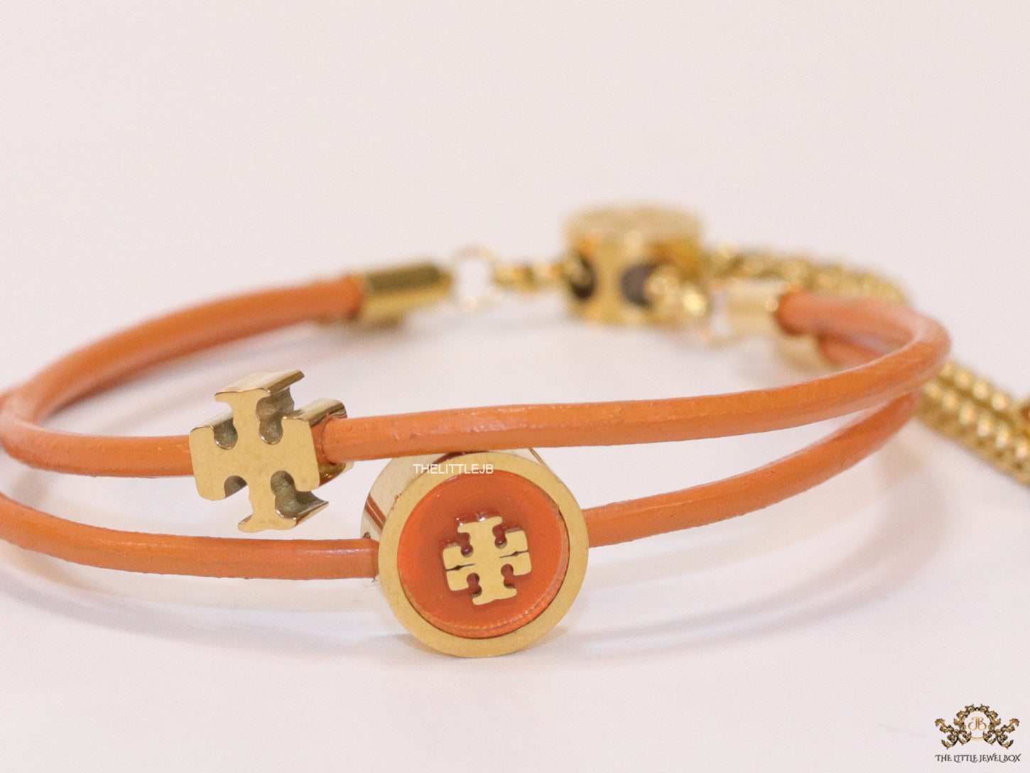 Adjustable double string orange bracelet with twin T motifs